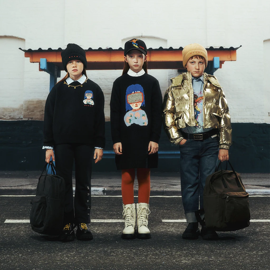 Three children standing with stylish and warm outfits