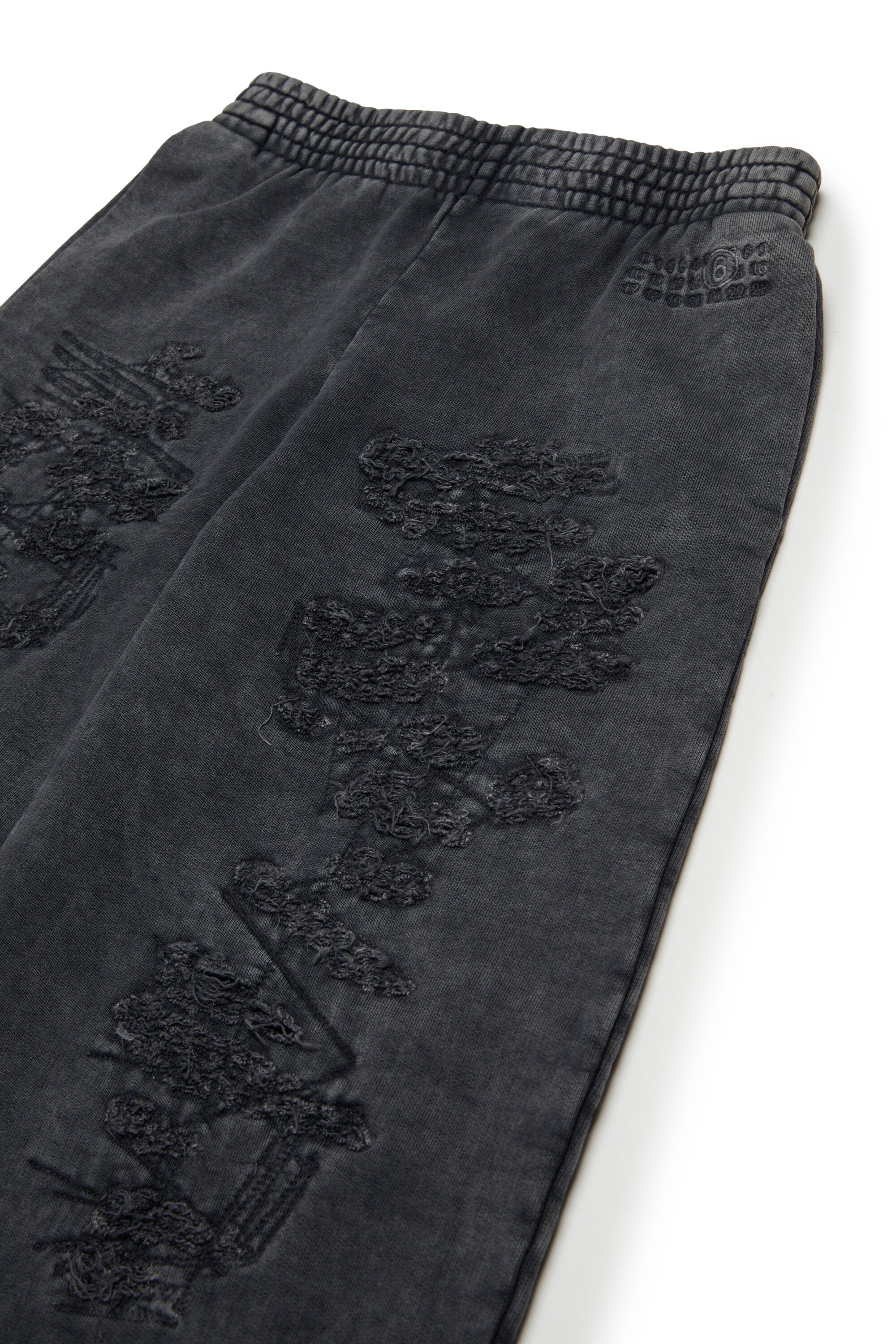 Pantalones sudadera con roturas zurcidas