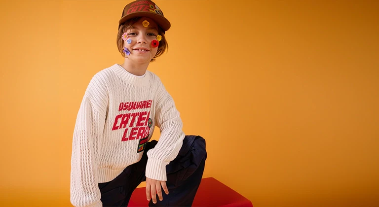 A boy wearing a stylish outfit with flowers on his face and a yellow background